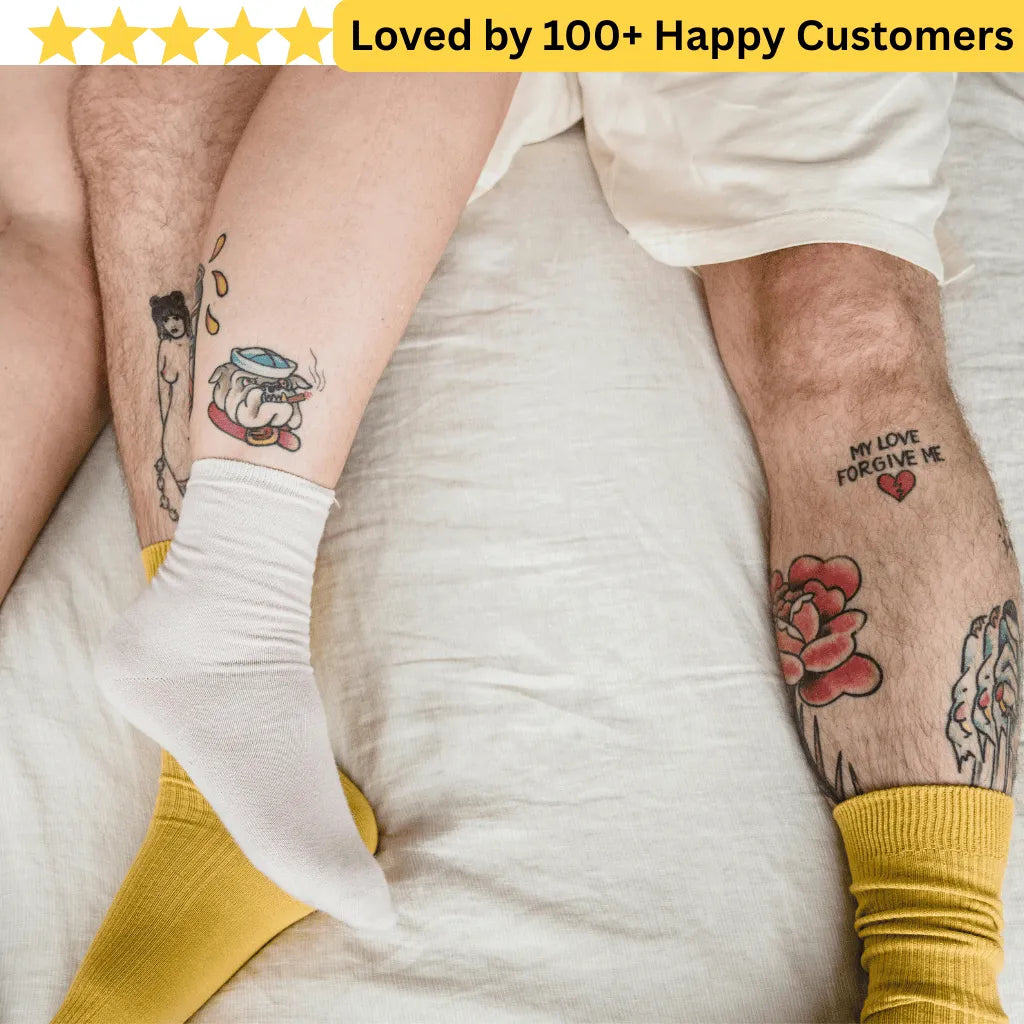 Two people with tattoos on their arms, wearing yellow socks, on a white background.