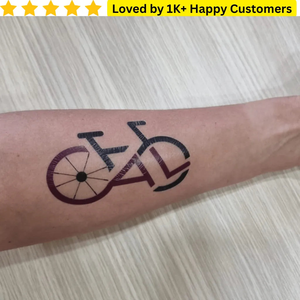 Tattoo of a bicycle on a person's arm with text 'Loved by 1K+ Happy Customers' above.