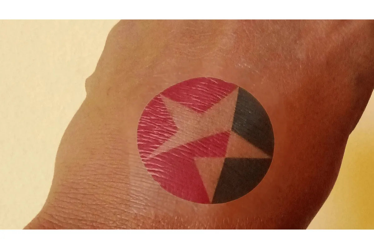 Tattoo of a red circle with a black triangle inside on a person's arm. Discover Why South African Brands & Event Planners Love TeMaRo™ Temporary Tattoos