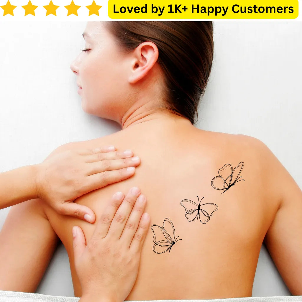 Person with butterfly tattoos on their shoulder and neck, with hands gently touching the skin. For Women Tattoos- Discover Elegant &amp; Meaningful