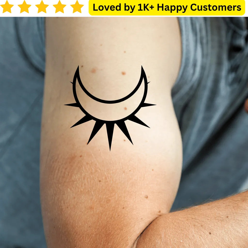 Black sun and moon tattoo on a person's arm with a gray shirt in the background. Men's Tattoos Arm for Testing Your Next Tattoo