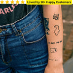 Person wearing blue jeans with visible tattoos on their arm, set against a blurred outdoor background. Custom Temporary Tattoos for Kids South Africa