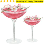 Two pink cocktails with floral garnishes in martini glasses on a white background. Celebrate your bride tribe with skin-safe Tattoo Bachelorette Party—designed for bachelorette parties across South Africa
