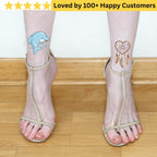 Transparent anklets with dolphin and heart tattoos on a wooden floor. tattoos for ladies feet