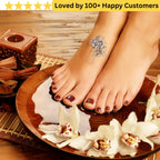 Feet with a temporary tattoo of a flower design, surrounded by white flowers and candles on a wooden surface. tattoos for ladies feet
