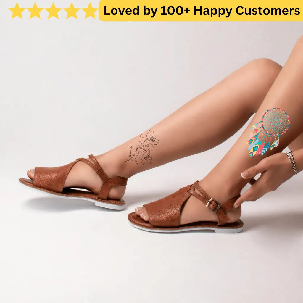 Brown sandals worn by a person with tattoos on a light gray background. tattoos for ladies feet