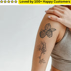 Tattoo of a floral design on a person's arm with a hand covering part of it, on a light gray background.